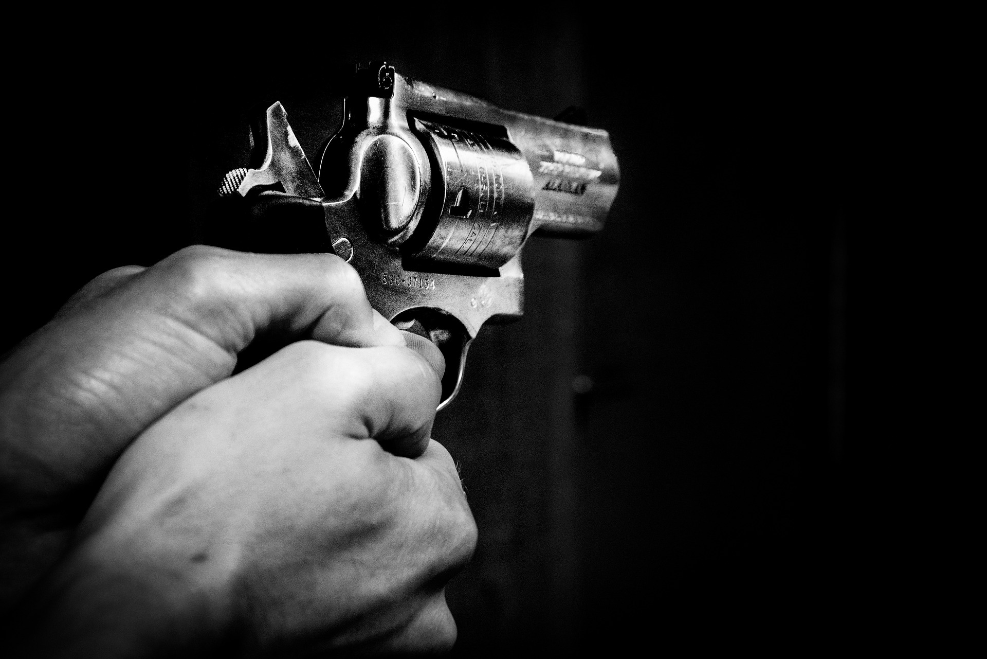 gun in the dark with light on the hands holding it