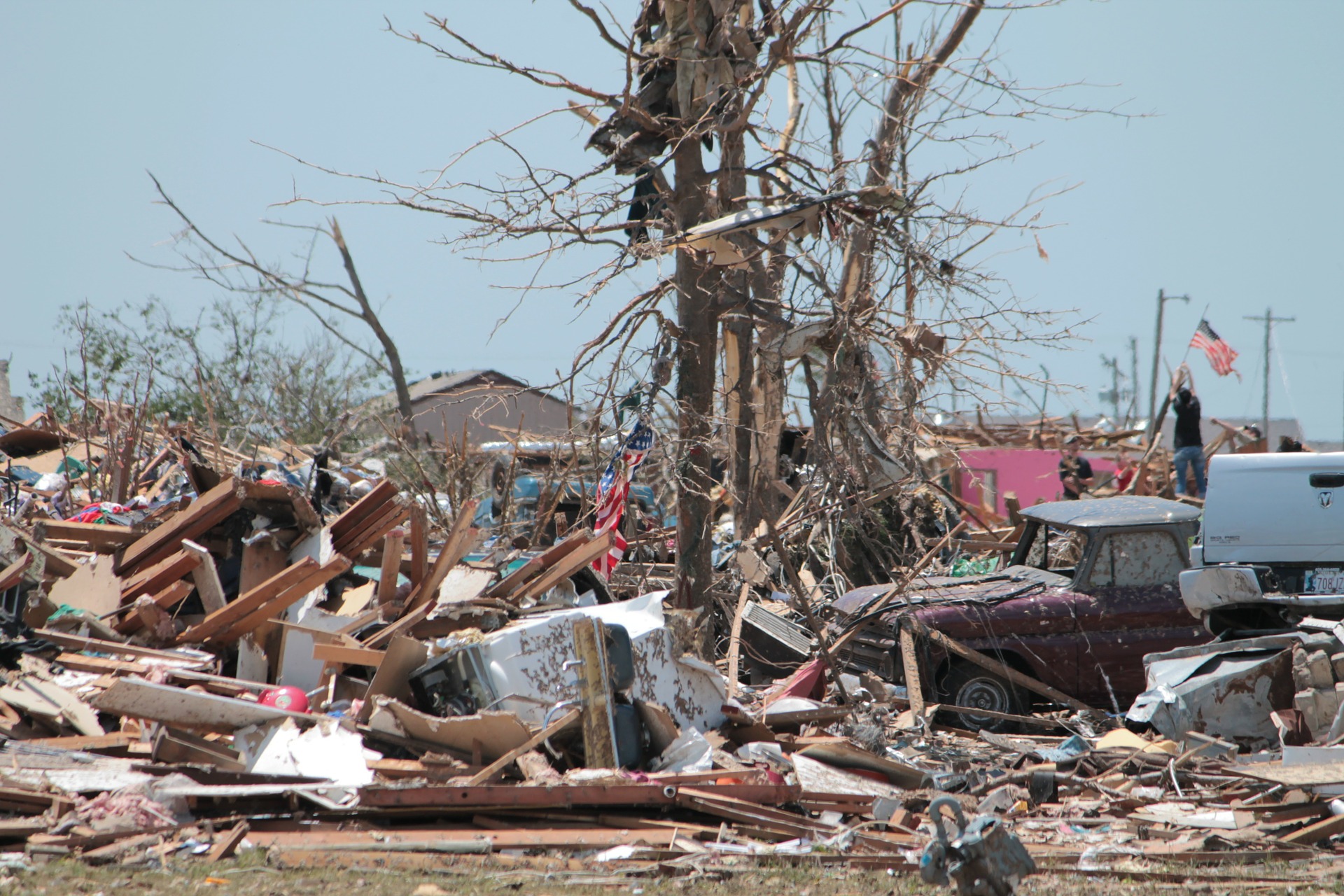 A tornado destroyed a town and a man raises a flag